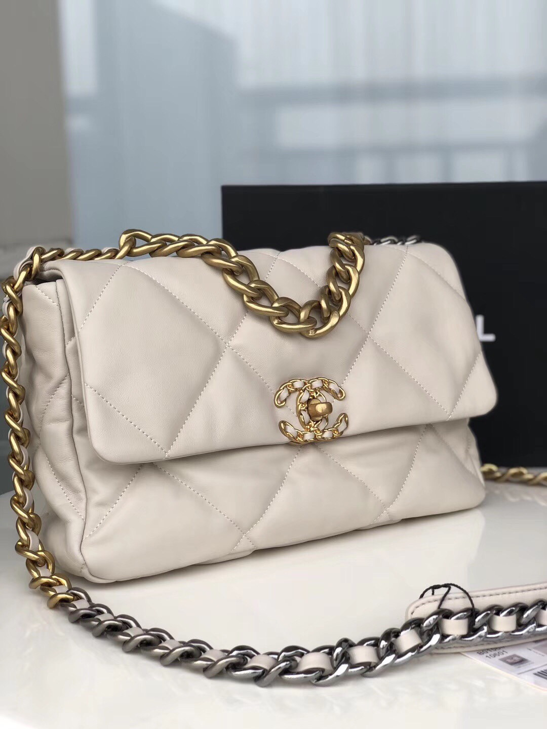 Ch*el 19 large handbag shiny leather, gold-tone, silver-tone & ruthenium-finish metal beige 7.8 × 11.7 × 3.9 in